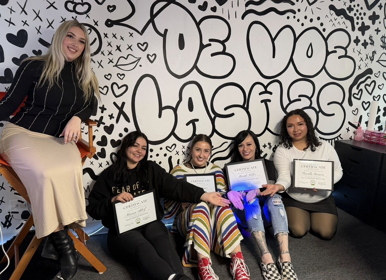 Cortney with a class of graduates in front of the De Voe Lashes mural