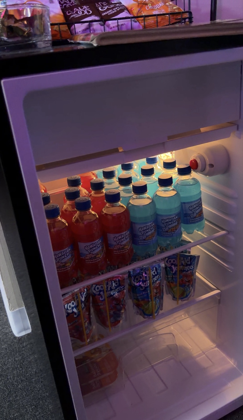 An open mini fridge stocked with drinks