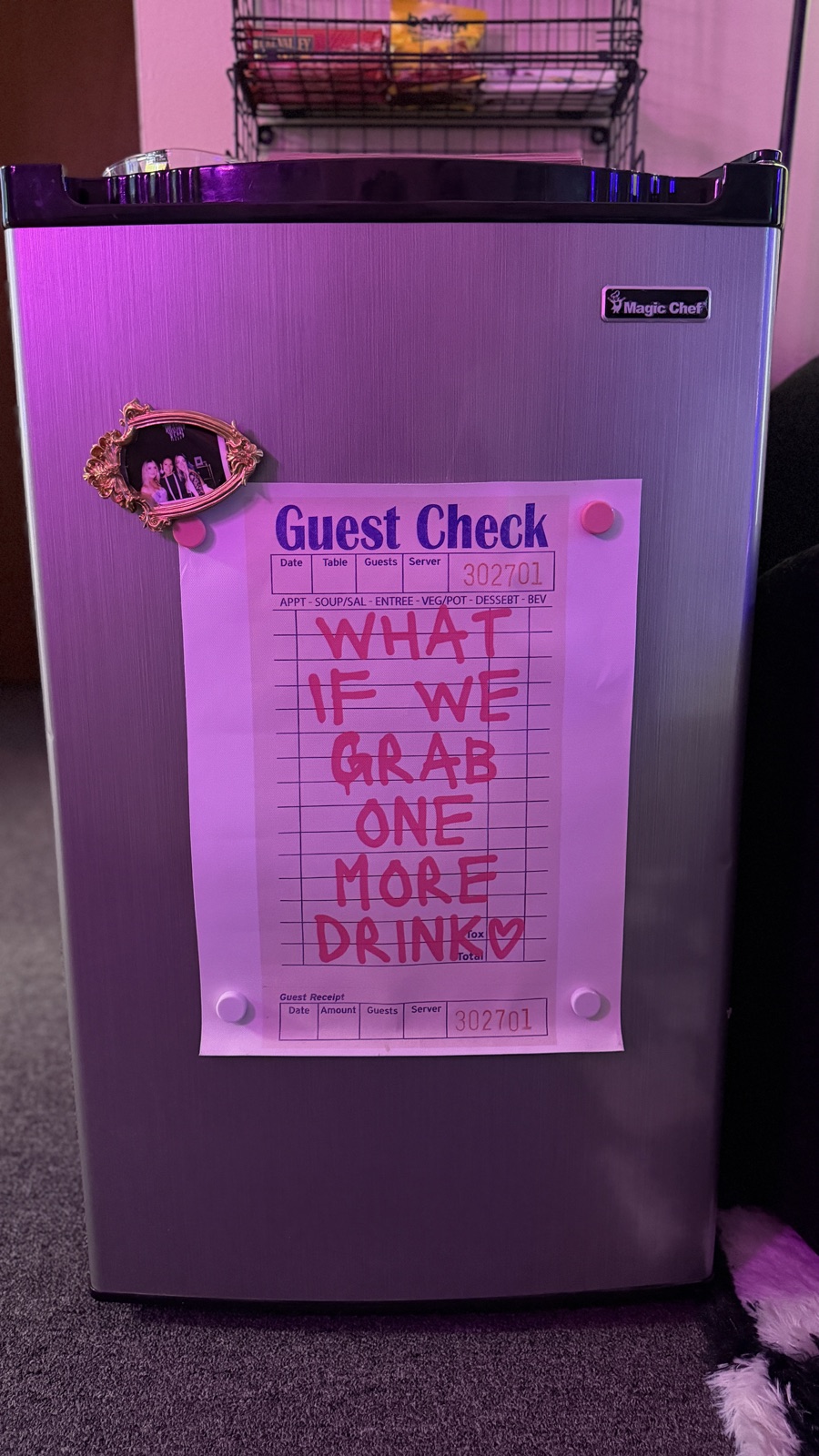 A guest check note on the fridge that reads what if we grab one more drink